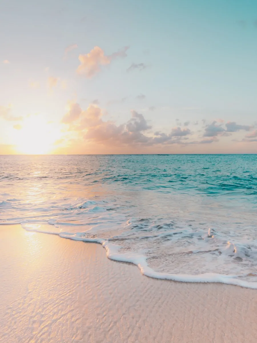 Praia ao pôr do sol com tons dourados